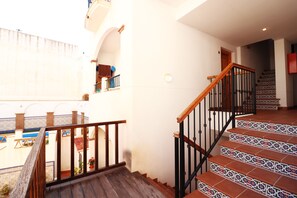 A staircase with patterned tiles and a wooden handrail.