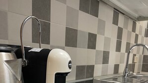 A kitchen with a coffee maker, kettle, and a sink. - Melly House: fast Wi-Fi, 5 minutes from the sea (Barletta)