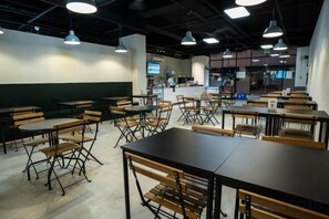 A restaurant with tables and chairs arranged in a spacious layout. - Hop Inn Ortigas Center Manila (Pasig)