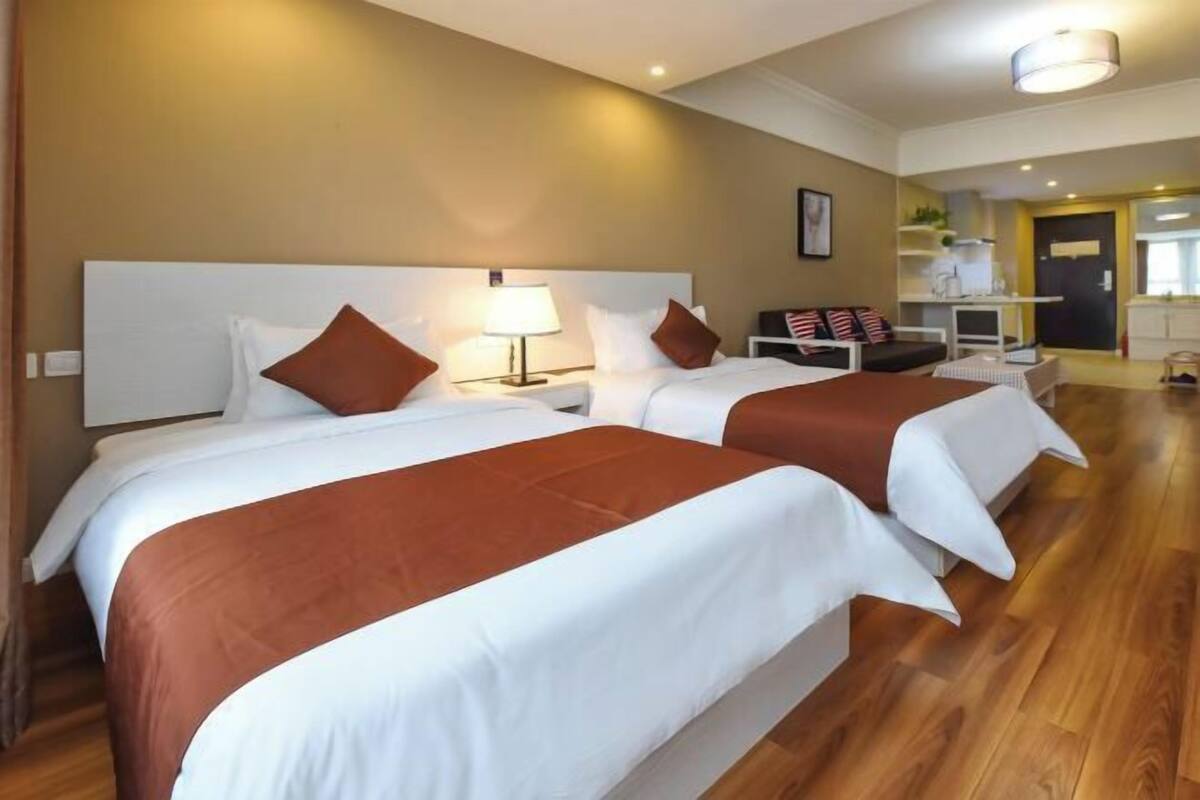 Una habitación de hotel con dos camas, un escritorio y una silla.