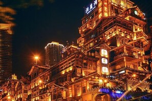 Un immeuble à plusieurs étages, doté d’une architecture traditionnelle, avec des balcons et une enseigne lumineuse.