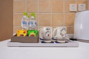 A kitchen counter with a tray holding Lipton tea bags, Lipton tea, and bottled water. - Sweetome Vacation Apartment (Galaxy) (Chongqing)