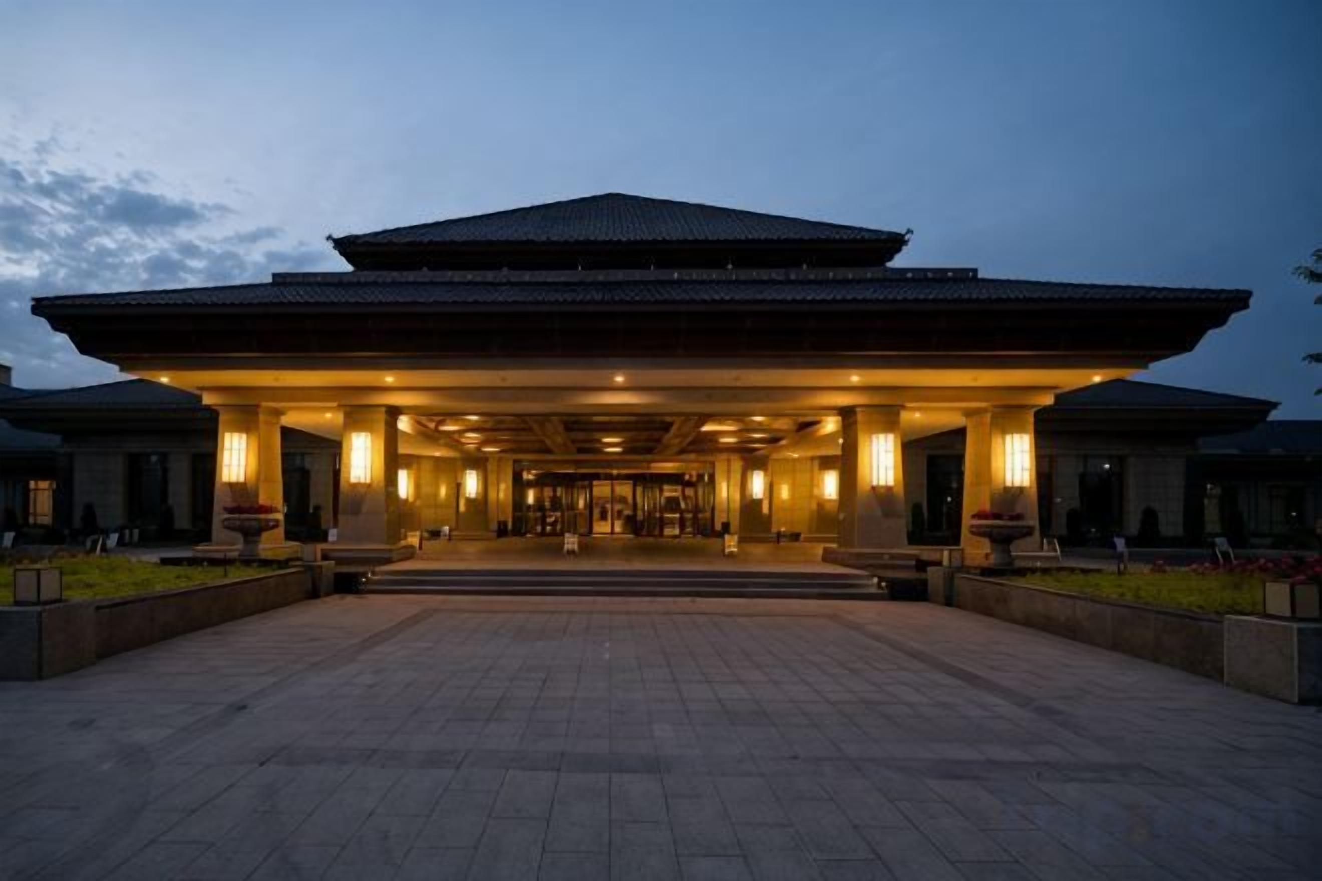 A large, traditional building with a covered entrance and a spacious courtyard.