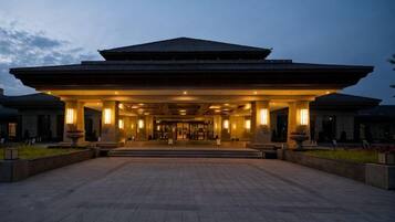 A large, traditional building with a covered entrance and a spacious courtyard.