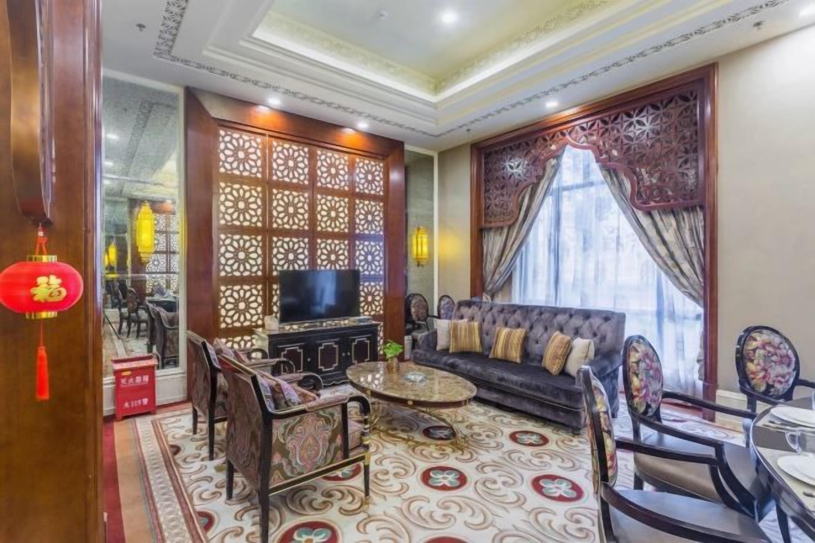 A traditional living room with a sofa, chairs, a coffee table, and a television.