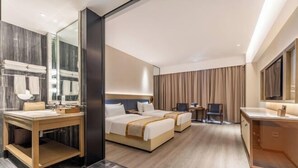 Een hotelkamer met een groot bed, een eigen badkamer, een bureau en een televisie.