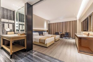 A hotel room with a large bed, a separate bathroom, a desk, and a television. - Changji Guesthouse (Changji)