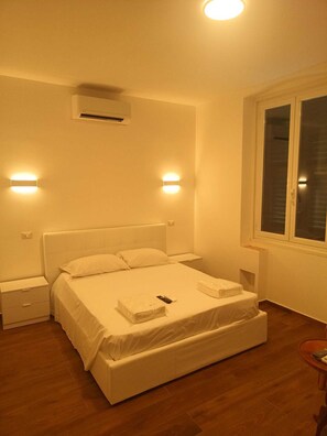 A bedroom with a bed, bedside tables, a window, and an air conditioning unit. - Ferry Terminal Apartment, 2 steps from embarkations, station, historic center (Genova)