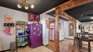 Eine Küche mit einem violetten Kühlschrank, Holzbalken und einem gefliesten Boden.