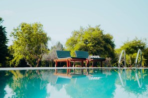 A clear swimming pool with lounge chairs and a diving board. - Pothana Village (Sigiriya)