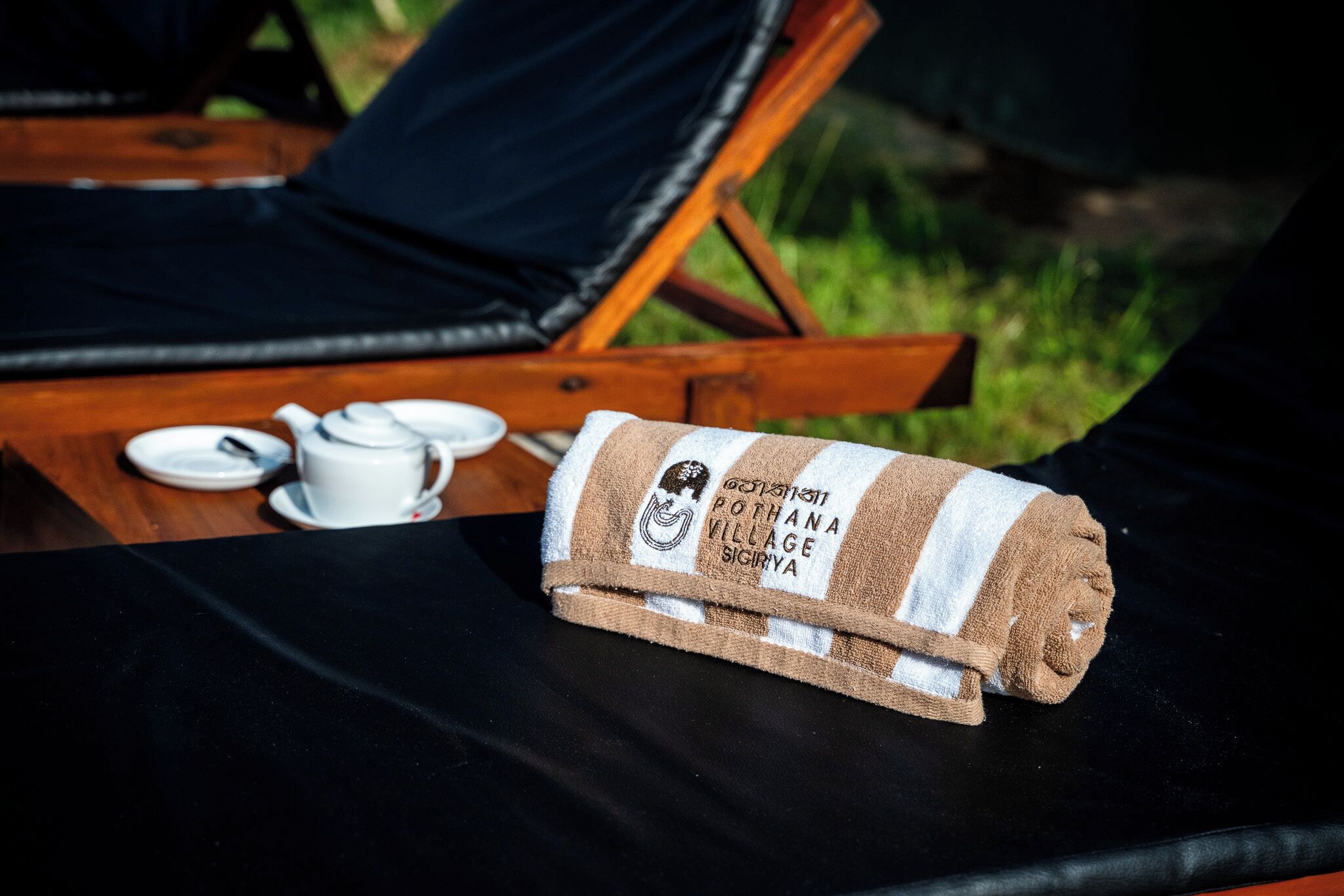 A towel with text, a cup, and a saucer on a table.