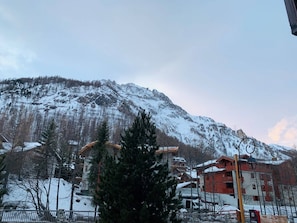 A mountainous landscape with snow-covered peaks and a town in the foreground.