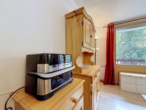 A kitchenette with a built-in microwave and a wooden cabinet.