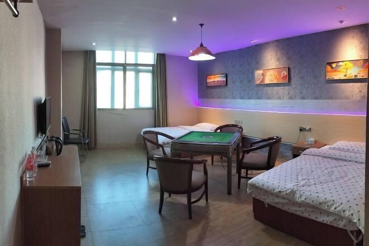 Une chambre d’hôtel équipée d’un lit, d’un bureau, d’une chaise, d’une table de billard et d’œuvres d’art accrochées aux murs.