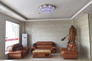 Una habitació amb un sofà, una taula de centre i una estàtua.