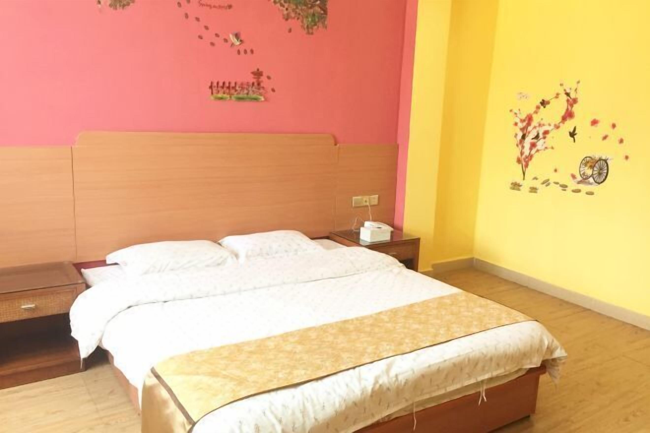 A bedroom with a wooden bed, white bedding, and a nightstand with a lamp.
