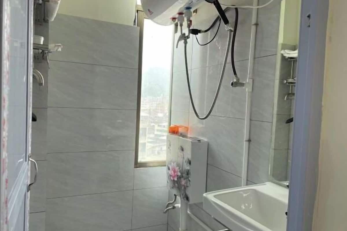Une salle de bain avec douche, toilettes et lavabo.