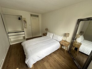 A bedroom with a bed, a wardrobe, a mirror, and bedside tables. - Fab Excel London Flat, Warm Cosy Liz Line (London)
