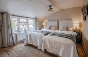 A bedroom with two beds, a large window, and a radiator. - Coastal/petsok/kingbed/wifi/garden (Driffield)