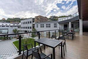 A rooftop terrace with outdoor seating and a view of surrounding buildings. - TongQianWan Hotel (Xiangshan)
