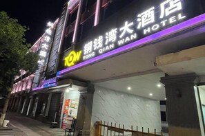 A hotel with a prominent sign, a covered entrance, and a visible staircase leading to the entrance. - TongQianWan Hotel (Xiangshan)