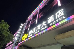 A hotel sign with illuminated neon lights and a name in both Chinese and English.