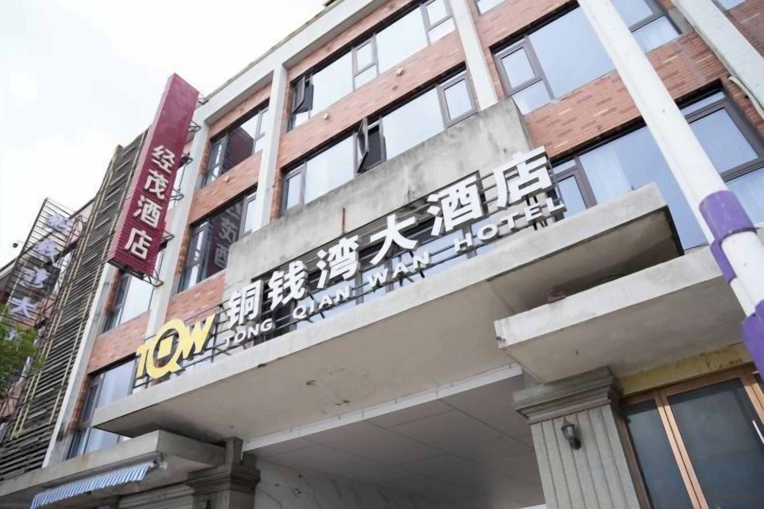 Un albergo con un cartello che indica che si tratta di un hotel e un nome che suggerisce una posizione in una regione di lingua cinese.