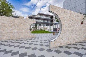 Un edificio moderno con un piso de patrón de cuadros y un hueco circular en la pared.