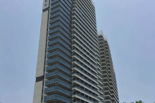 Een hoog, modern gebouw met een gelijkmatige gevel en veel ramen.