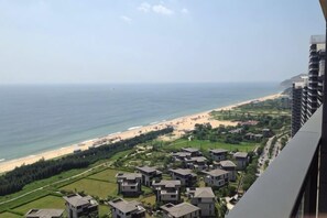 Blick auf die Küste mit Strand, Wohngebäuden und blauem Himmel.