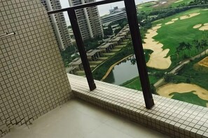 Varanda com vista para um campo de golfe e um rio.
