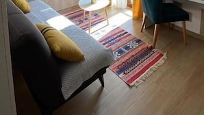 A modern hotel room with a bed, a desk, a chair, a TV, and a window with curtains. - Hotel Villa Lejla (Mostar)