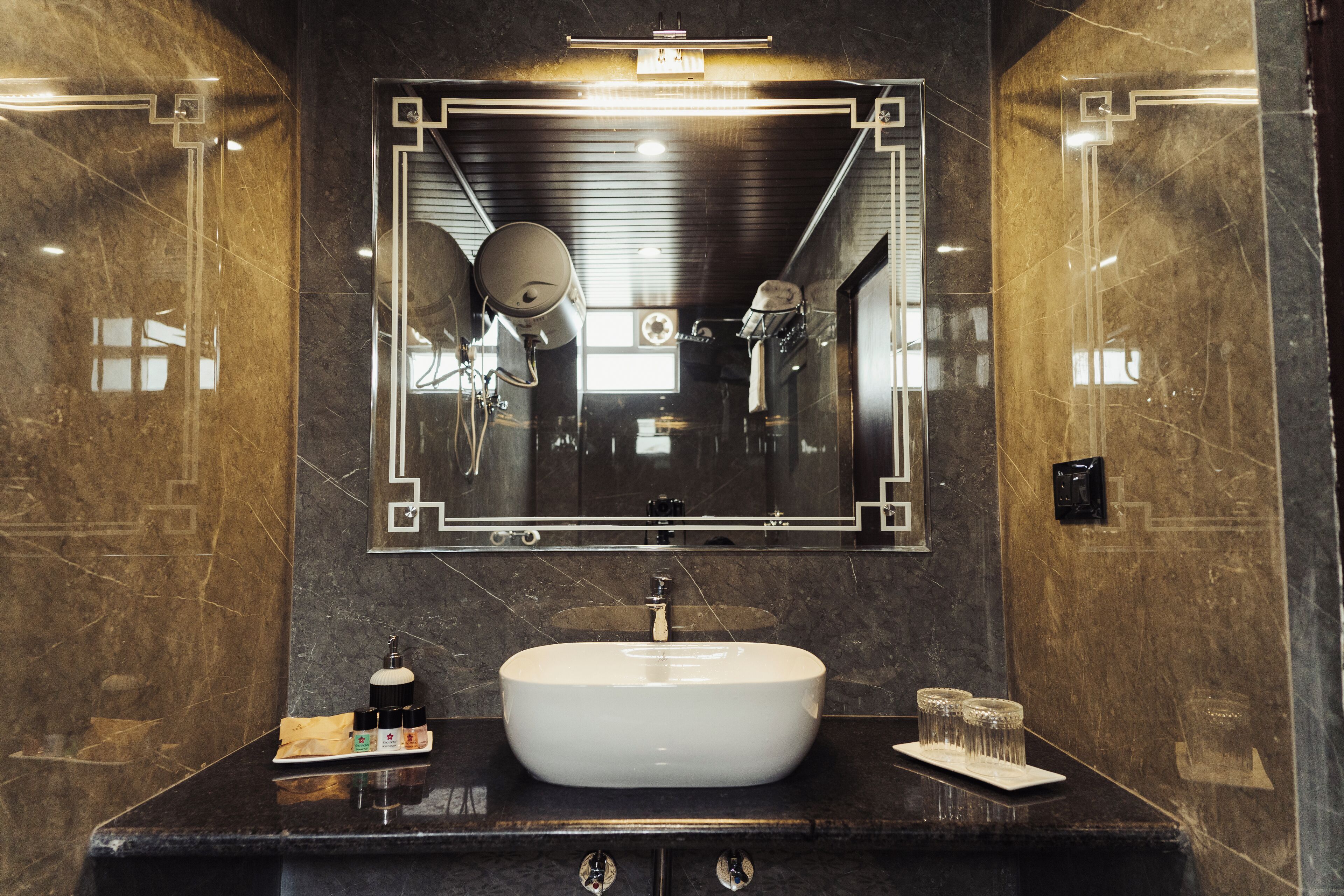 A bathroom with a large mirror, a sink, and a towel rack.