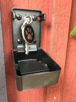 A secure storage container with a hinged lid and keychain inside.