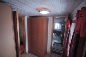 Features a spacious room with a wardrobe, door to adjacent room, and a curtain.