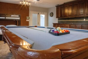 Enjoy a game of pool in this classic room with a pool table, cues, and billiard balls.