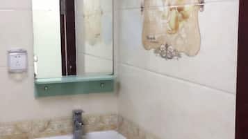 A bathroom with a sink, mirror, and decorative wall tiles.