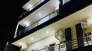 Un edificio de varios pisos con un llamativo letrero de "UmRa" a nivel de la calle.