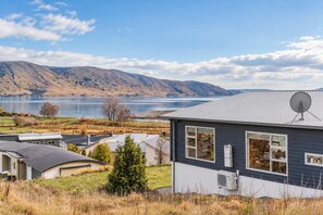 A residential area with houses, a lake, and mountains in the background. - Starry Slumber in Lake Tekapo | Views & Parking (Lake Tekapo)