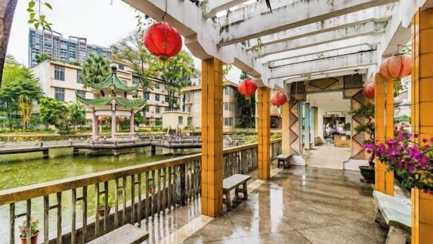 A courtyard with a traditional pavilion, a small pond, and red lanterns. - Qujiangying Hotel (Shaoguan)