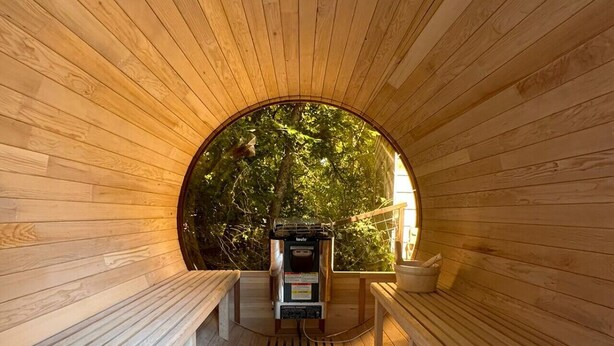 A wooden sauna with benches and a sauna machine. - Modern Treehouse Retreat, Cold Plunge (Austin)