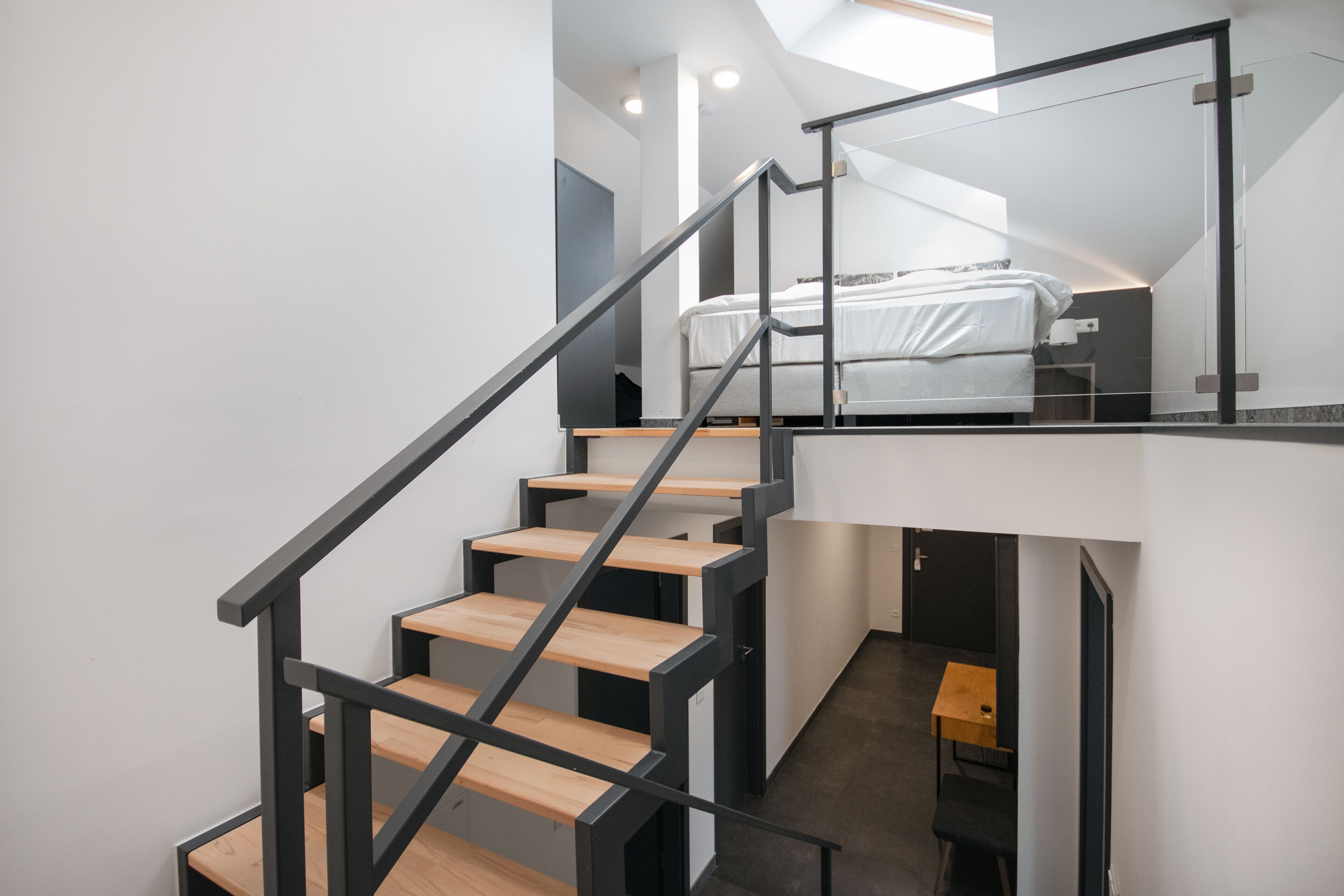 A modern interior with a staircase leading to a loft bedroom.