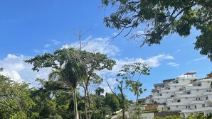 Ein Wohngebiet mit einer gewundenen Straße, üppiger Vegetation und weißen Gebäuden mit zahlreichen Balkonen.