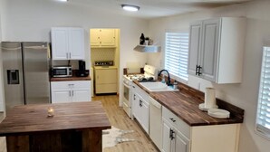 A modern kitchen with white cabinets, a wooden countertop, and stainless steel appliances. - Cozy Lake House Surrounded by Mountain's (Wofford Heights)