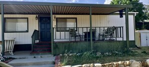 Una casa de un piso con un porche cubierto, una puerta principal y unos pocos escalones que llevan a la entrada.