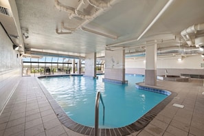 An indoor swimming pool with clear water, tiled walls, and a view through large windows. - Phoenix VII 1408 by Liquid Life (Orange Beach)