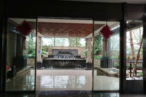 A reception area with a stone fountain, glass doors, and a sign that reads 'PORTION.'