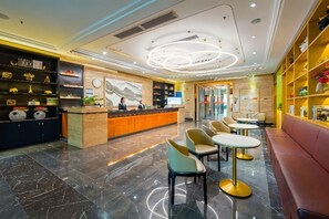 A hotel lobby with a reception desk, seating area, and a reception counter.