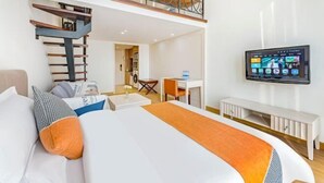 Une chambre d’hôtel avec un lit, un bureau, une chaise, une télévision et un escalier.