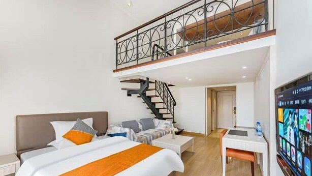 Una habitación de hotel moderna con una cama grande, un escritorio, una escalera y un balcón.